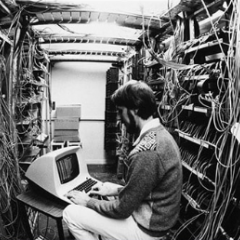Man in computer room with older style terminal computer