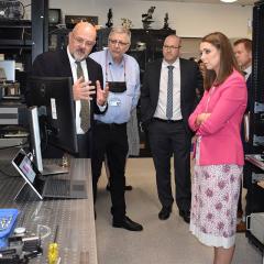 Minister in lab with professors