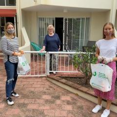 Shopping Angels co-founders Julian Corvin (left) and Tara O'Kane (right) deliver groceries to Cherese, who is self-isolating on the Gold Coast.